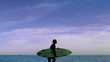 Woman running on the beach with her surfboard