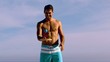 Shirtless man bouncing ball on a racket
