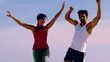 Man and woman jumping together on the beach