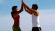 Happy couple high fiving on the beach