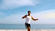 Man jumping with arms up on the beach