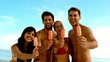 Friends laughing with ice cream on the beach