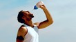 Sportsman rehydrating with water on the beach