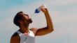 Athletic man rehydrating with water on the beach
