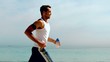 Athletic man jogging across the beach