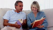 Mature people reading books on the couch