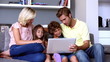 Family on the couch looking at laptop