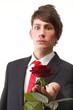 Young man presenting a flower red rose isolated