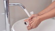 Someone washing their hands at the sink in bathroom