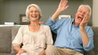 Elderly couple laughing and looking to the camera