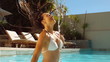 Woman in swimming pool tossing her wet hair 