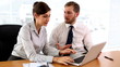Business partners discussing something on laptop