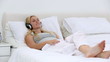 Blonde woman listening to music on bed