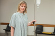 Thoughtful woman holding a drip stand while walking 