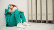 Tired nurse sitting on the floor