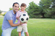 Portrait of father and son with a football