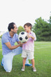 Happy father and son holding a football