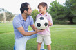 Father and son holding a football