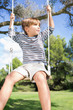 Little boy on a swing hanging from tree