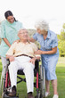 Man in wheelchair chatting with his nurse and partner