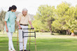 Elderly man walking in park with zimmer frame