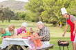 Happy family at picnic table with father at the barbeque