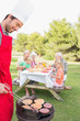 Father cooking barbecue for family