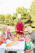 Father serving lunch to family at picnic table