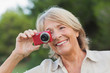 Smiling older woman taking a photo