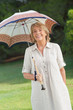 Smiling older woman holding umbrella