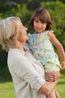 Woman holding her cute granddaughter who is looking at camera