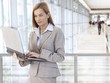 Businesswoman using laptop in office lobby