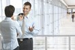 Foto: Business people talking in office lobby Business people talking in office lobby