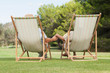 Couple in deck chairs holding hands