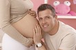 Photo: Happy father listening to pregnant tummy Happy father listening to pregnant tummy