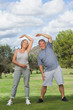 Mature woman and man stretching arms