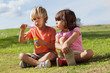 Little boy and girl blowing bubbles