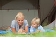 Mother and son reading on a sleeping bag