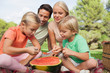 Happy family having watermelon at a picnic