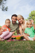 Young attractive family having watermelon at a picnic portrait