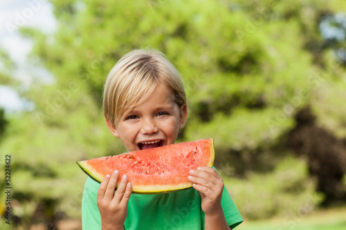 Photo: Cute happy boy eating watermelon Cute happy boy eating watermelon