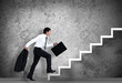 Businessman climbing the stairs to the top
