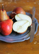 Fresh ripe pears in a plate with napkin and knife