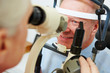 Senior man at optician looking in slit lamp