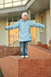 smiling girl standing on stone curb