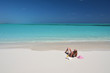 Girl with a glass of orange juice on the beach of Exuma, Bahamas