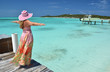 Girl on the wooden jetty looking to the ocean. Exuma, Bahamas