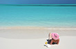 Girl with a glass of orange juice on the beach of Exuma, Bahamas