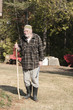 old man with kufi hat and stick looking at camera