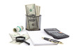 Dollar banknotes, magnifying glass, a calculator, a notepad and